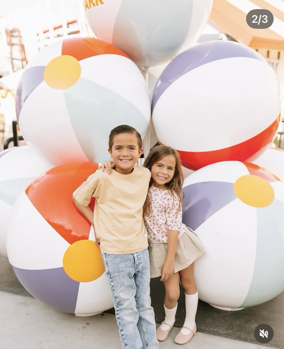 Children posing in front of oversized beach ball display