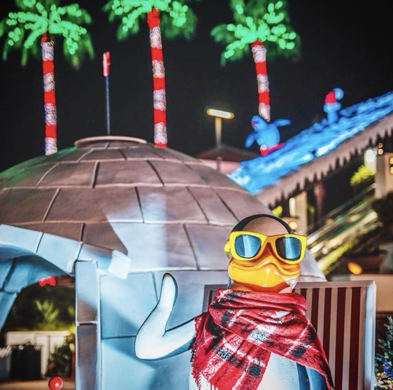 Penguin character display with palm tree lights