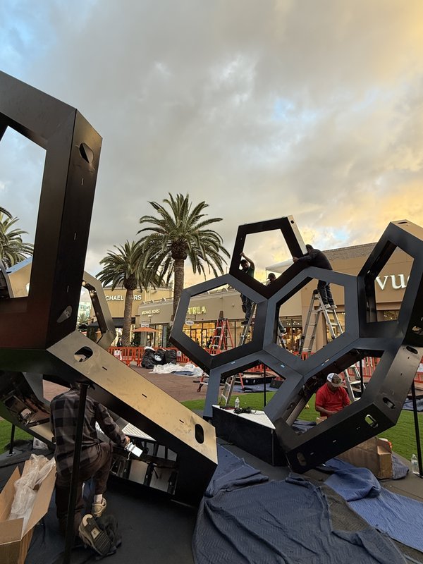 Steel hexagonal frame of the soccer ball being assembled during the day at The Citadel Outlets